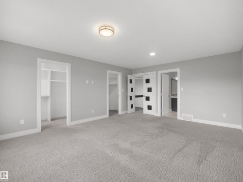 Neutral-toned wall paint, recessed lighting, flush-mount ceiling light fixture, sliding closet doors, and light gray patterned carpet - 17020 62 Street Nw, Edmonton, AB - Indoor Photo Showing Other Room