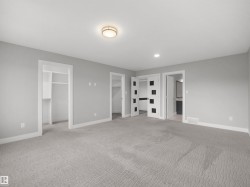 Neutral-toned wall paint, recessed lighting, flush-mount ceiling light fixture, sliding closet doors, and light gray patterned carpet - 