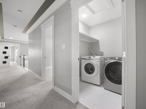 Dedicated laundry closet with ceramic tile flooring and integrated shelving - 17020 62 Street Nw, Edmonton, AB - Indoor Photo Showing Laundry Room