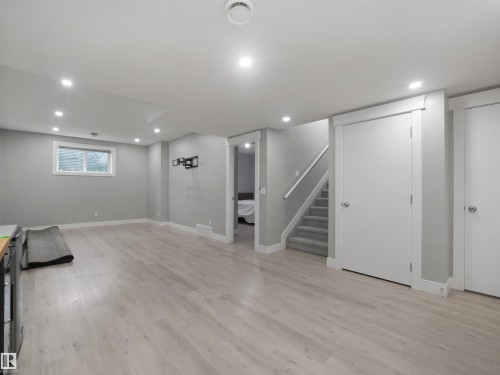 Recessed lighting, wood-finish flooring, light gray wall paint, white trim, and a carpeted staircase - 17020 62 Street Nw, Edmonton, AB - Indoor Photo Showing Other Room
