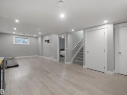 Recessed lighting, wood-finish flooring, light gray wall paint, white trim, and a carpeted staircase - 