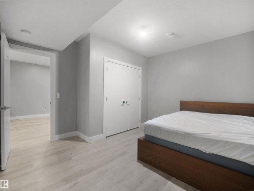 Light-toned wood-finish flooring throughout, bright white trim, and a white interior door - 17020 62 Street Nw, Edmonton, AB - Indoor Photo Showing Bedroom