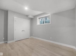 Light wood-finish flooring, white trim, and a white window frame complement the neutral wall tones - 