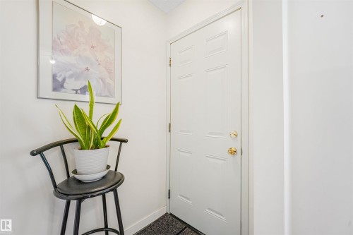 White paneled door with brass hardware, set against a light-colored wall - 18611 57 Avenue Nw, Edmonton, AB - Indoor Photo Showing Other Room