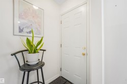 White paneled door with brass hardware, set against a light-colored wall - 