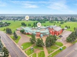 Aerial perspective showcasing a large institutional building with a red brick facade and green roofing - 