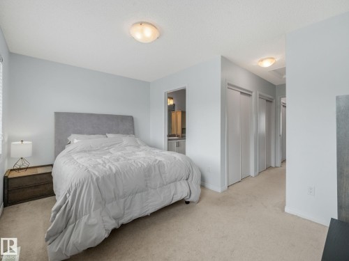 Spacious room featuring light blue walls, soft carpet flooring, and flush-mount ceiling lighting - #21 1140 Chappelle Bv Sw, Edmonton, AB - Indoor Photo Showing Bedroom
