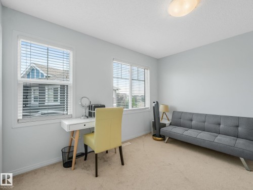 Versatile room featuring two windows with white blinds, neutral carpeting, and light-colored walls - #21 1140 Chappelle Bv Sw, Edmonton, AB - Indoor