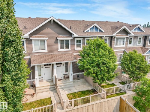 Townhome exterior featuring brown siding, white trim, and a brown shingle roof - #21 1140 Chappelle Bv Sw, Edmonton, AB - Outdoor