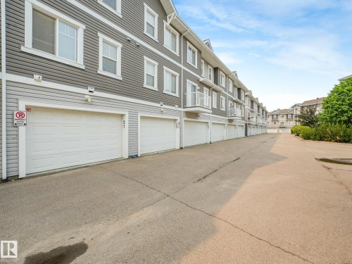 Row of attached garages with white sectional doors - #21 1140 Chappelle Bv Sw, Edmonton, AB - Outdoor