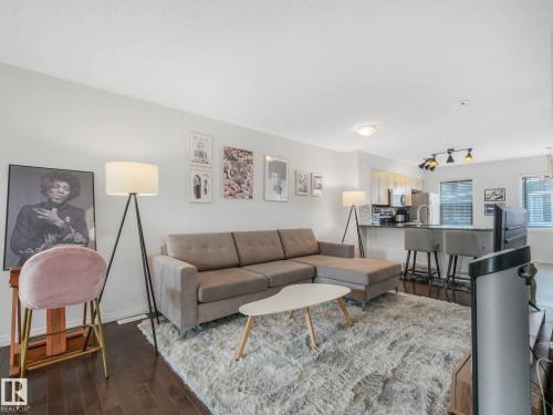 Open-concept living area featuring rich wood-finish flooring - #21 1140 Chappelle Bv Sw, Edmonton, AB - Indoor Photo Showing Living Room