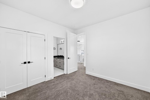 Gray carpeted flooring, white walls, white doors with dark hardware, and a ceiling light fixture - 3101 Soleil Boulevard, Beaumont, AB - Indoor Photo Showing Other Room
