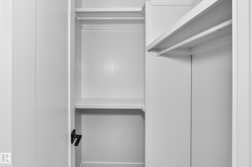 White built-in shelving, white hanging rods, and white interior panels - 3101 Soleil Boulevard, Beaumont, AB - Indoor Photo Showing Other Room