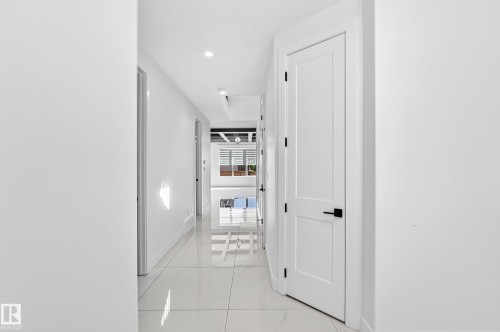 Recessed lighting, tile flooring, contemporary white interior doors, and matte black door hardware - 3101 Soleil Boulevard, Beaumont, AB - Indoor Photo Showing Other Room
