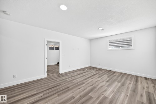 Recessed lighting, wood-finish flooring, white trim, and a window with horizontal blinds - 3101 Soleil Boulevard, Beaumont, AB - Indoor Photo Showing Other Room