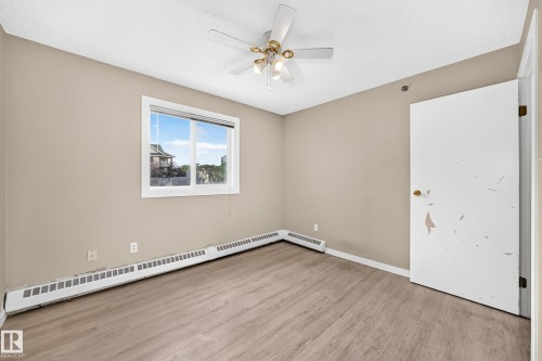 Wood-finish flooring with neutral wall tones - #204 11218 80 St Nw, Edmonton, AB - Indoor Photo Showing Other Room