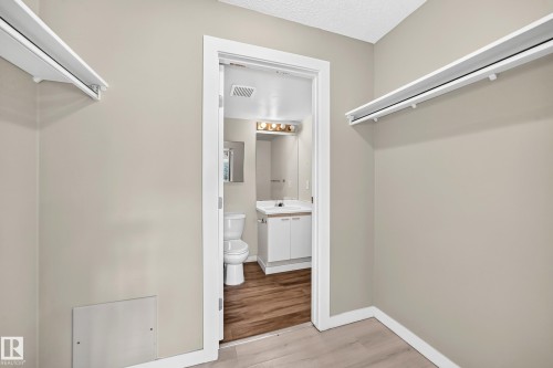 White hanging rods, light-toned walls, and wood-finish flooring - #204 11218 80 St Nw, Edmonton, AB - Indoor