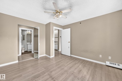 Wood-finish flooring with a ceiling fan and light fixture - #204 11218 80 St Nw, Edmonton, AB - Indoor Photo Showing Other Room