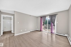 Light gray wall paint, wood-finish flooring, sliding glass door, white trim, and a full bathroom with a white tub - 