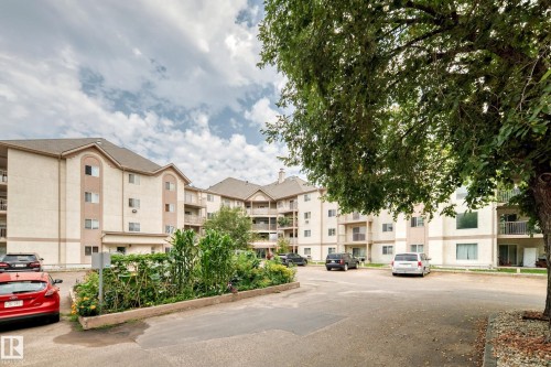 Multi-story building featuring multiple balconies, a pitched roof, and an exterior of light-colored siding - #204 11218 80 St Nw, Edmonton, AB - Outdoor With Balcony With Facade