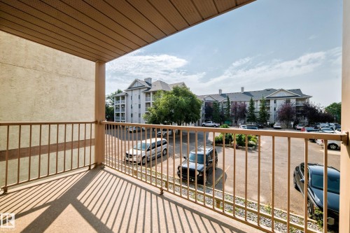 Private balcony with metal railing, textured exterior wall, and overhead soffit - #204 11218 80 St Nw, Edmonton, AB - Outdoor With Balcony With Exterior