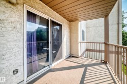 Private balcony featuring a stucco exterior, sliding glass door, and metal railings - 