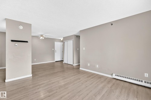 Wood-finish flooring, neutral wall tones, baseboard heating, ceiling fan with integrated lighting, and bi-fold closet doors - #204 11218 80 St Nw, Edmonton, AB - Indoor Photo Showing Other Room