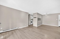 Wood-finish flooring throughout, light neutral wall paint, and a ceiling fan with integrated lighting - 