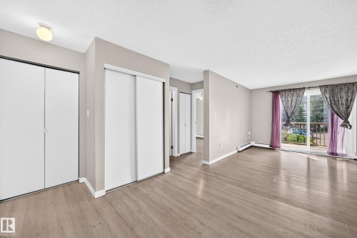 Wood-finish flooring throughout - #204 11218 80 St Nw, Edmonton, AB - Indoor Photo Showing Other Room