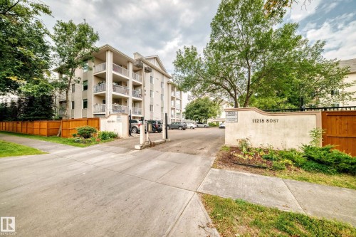 Multi-story building with exterior balconies, a private property sign, and a fenced perimeter - #204 11218 80 St Nw, Edmonton, AB - Outdoor With Balcony