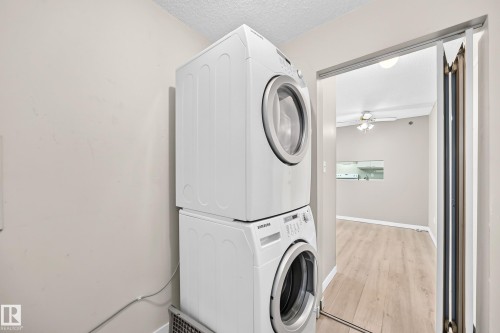 Stacked white laundry appliances - #204 11218 80 St Nw, Edmonton, AB - Indoor Photo Showing Laundry Room