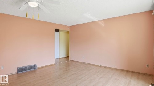 Wood-finish flooring with a ceiling fan light fixture - 8408 176 Street Nw, Edmonton, AB - Indoor Photo Showing Other Room