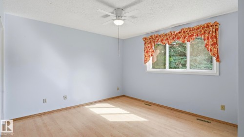 Wood-finish flooring, ceiling fan with integrated lighting, and a multi-pane window - 8408 176 Street Nw, Edmonton, AB - Indoor Photo Showing Other Room