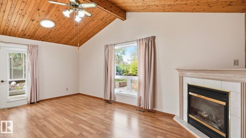 Vaulted wood-paneled ceiling, recessed circular lighting, wood-finish flooring, fireplace with tiled surround, and multiple windows - 8408 176 Street Nw, Edmonton, AB - Indoor With Fireplace