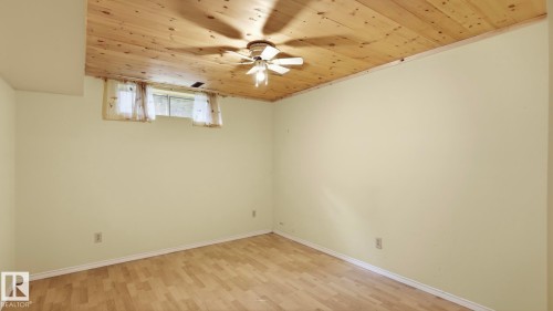 Wood-finish flooring, wood-paneled ceiling, ceiling fan with integrated lighting, and a single window - 8408 176 Street Nw, Edmonton, AB - Indoor Photo Showing Other Room