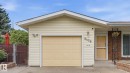Attached garage with a panel door, vinyl siding, concrete driveway, and a chain link fence - 8408 176 Street Nw, Edmonton, AB  - Outdoor With Exterior 
