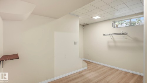 Wood-finish flooring, drop ceiling with recessed lighting, and a basement window - 8408 176 Street Nw, Edmonton, AB - Indoor