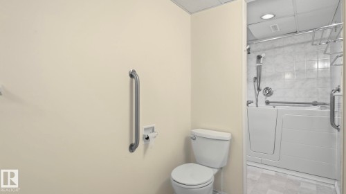Walk-in tub with grab bars, tiled shower surround, recessed lighting, and a chrome shower fixture - 8408 176 Street Nw, Edmonton, AB - Indoor Photo Showing Bathroom