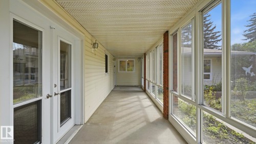 Enclosed screened porch featuring expansive windows, light-filled cement flooring, and multiple glass-panel doors providing direct access to outdoor spaces - 8408 176 Street Nw, Edmonton, AB - Outdoor With Exterior