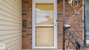 Brick exterior with tan siding and a storm door - 8408 176 Street Nw, Edmonton, AB  - Outdoor With Exterior 