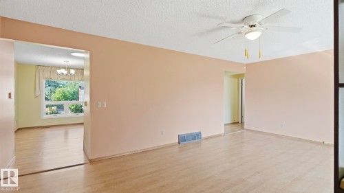 Wood-finish flooring throughout, ceiling fan with integrated lighting, and neutral wall tones - 8408 176 Street Nw, Edmonton, AB - Indoor Photo Showing Other Room