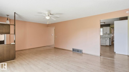 Wood-finish flooring, built-in shelving, ceiling fan with light fixture, and a spacious room layout - 8408 176 Street Nw, Edmonton, AB - Indoor