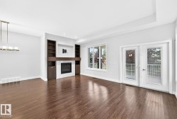 Hardwood flooring, recessed lighting, built-in shelving, fireplace, and double French doors - 