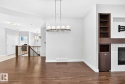 Hardwood flooring, built-in shelving, built-in cabinetry, fireplace, and chandelier lighting - 