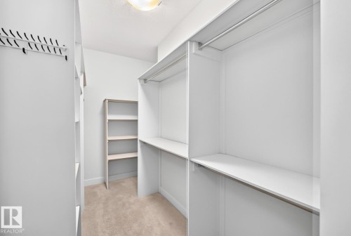 Built-in shelving, hanging rods, and recessed lighting - #57 18343 Lessard Rd Nw, Edmonton, AB - Indoor