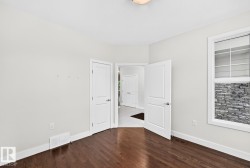 Hardwood flooring, painted walls, white trim, recessed lighting, and a window with stone exterior detailing - 