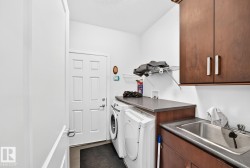 Laundry area featuring wood-finish cabinetry, a utility sink, and a work surface - 
