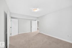 Neutral wall paint, plush carpeting, white trim, flush mount ceiling light, and interior doors with paneling - 