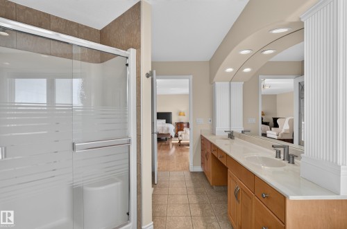 Dual vanity with undermount sinks, frosted glass shower enclosure, wood-finish cabinetry, and recessed lighting - 13527 158 Avenue Nw, Edmonton, AB - Indoor Photo Showing Bathroom