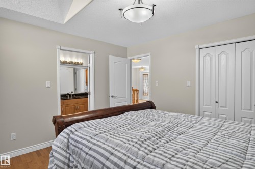 Wood-finish flooring, vaulted ceiling, and bi-fold closet doors - 13527 158 Avenue Nw, Edmonton, AB - Indoor Photo Showing Bedroom